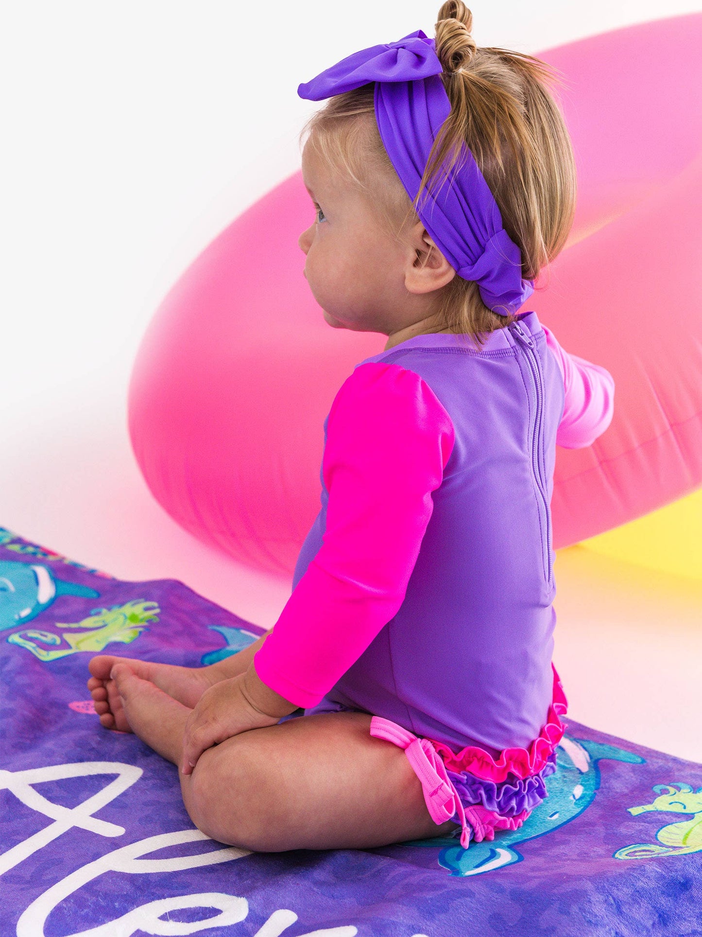 RuffleButts + RuggedButts - Baby Girls Neon Purple Color Block Long Sleeve One Piece Rash Guard Swimsuit with Signature Rear Ruffles: Purple