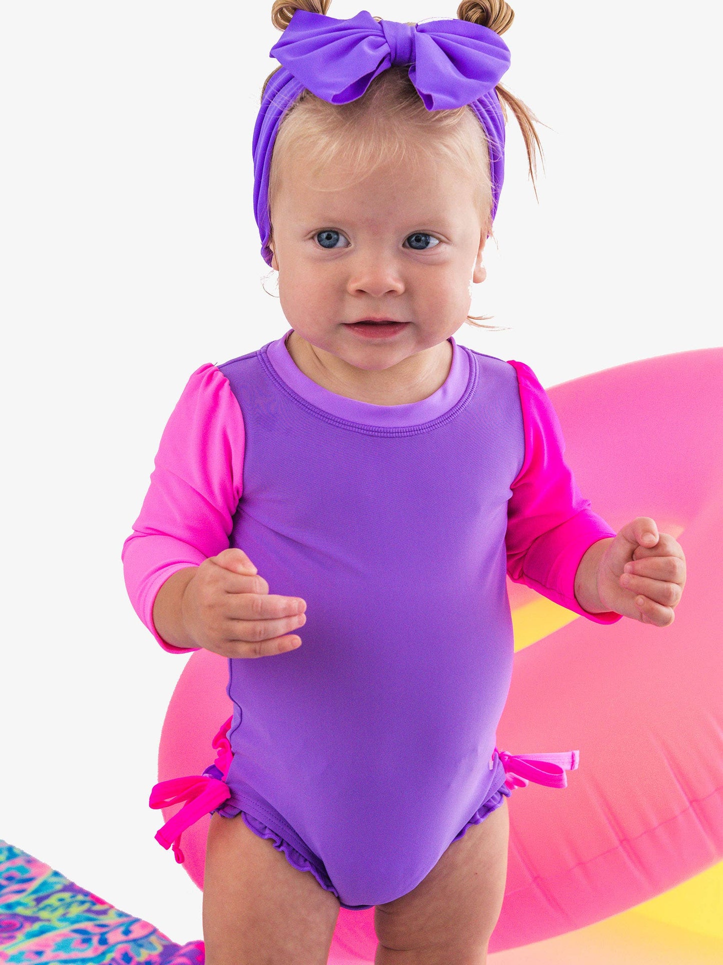 RuffleButts + RuggedButts - Baby Girls Neon Purple Color Block Long Sleeve One Piece Rash Guard Swimsuit with Signature Rear Ruffles: Purple