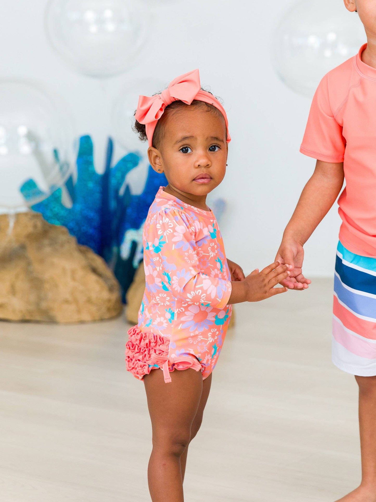 RuffleButts + RuggedButts - Baby Girls Coral Floral Long Sleeve One Piece Rash Guard Swimsuit with Signature Rear Ruffles: Orange